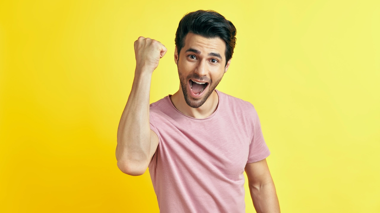 ガッツポーズするTシャツ姿の外国人男性